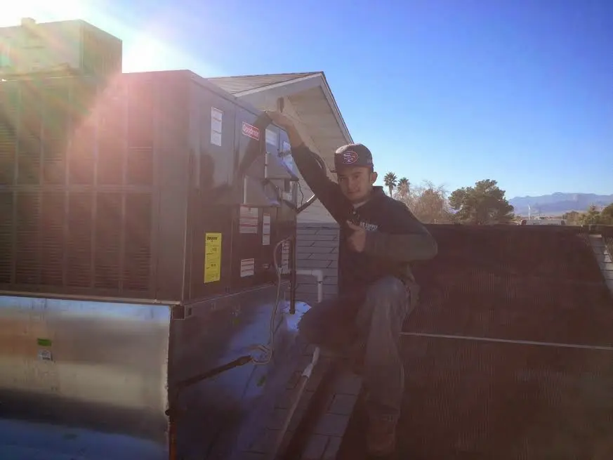 HVAC technician performing Air Duct Cleaning on a rooftop unit in Wauconda